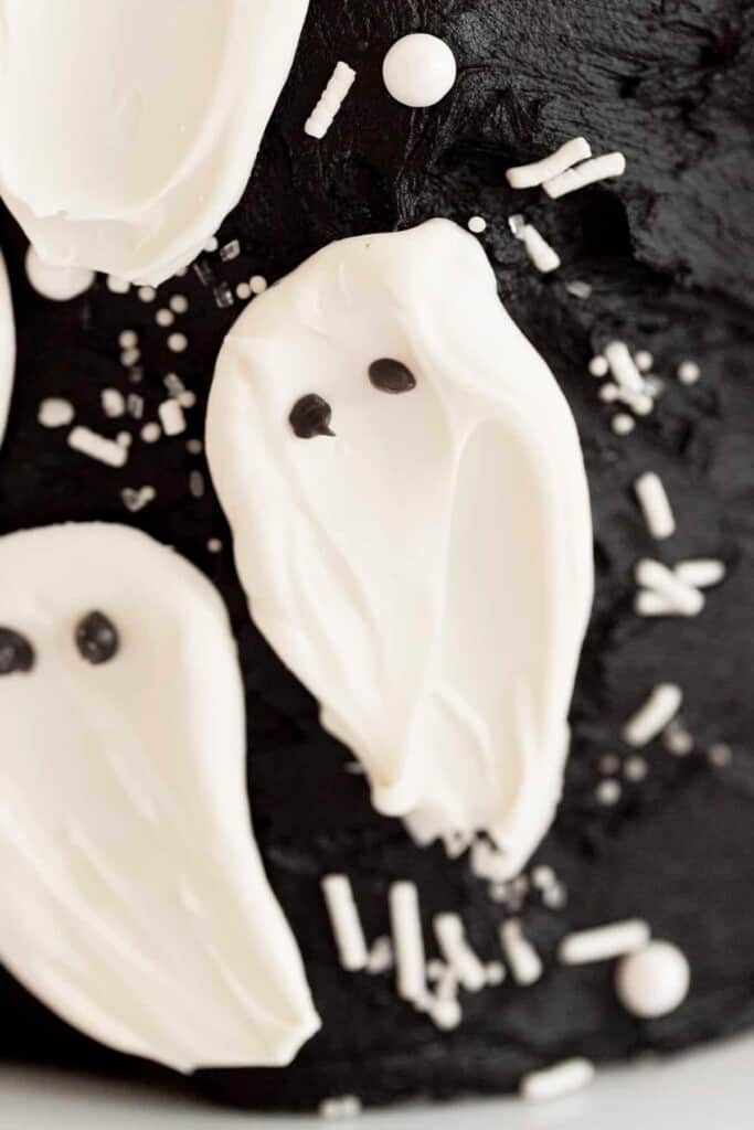 candy melt ghosts on a cake with sprinkles