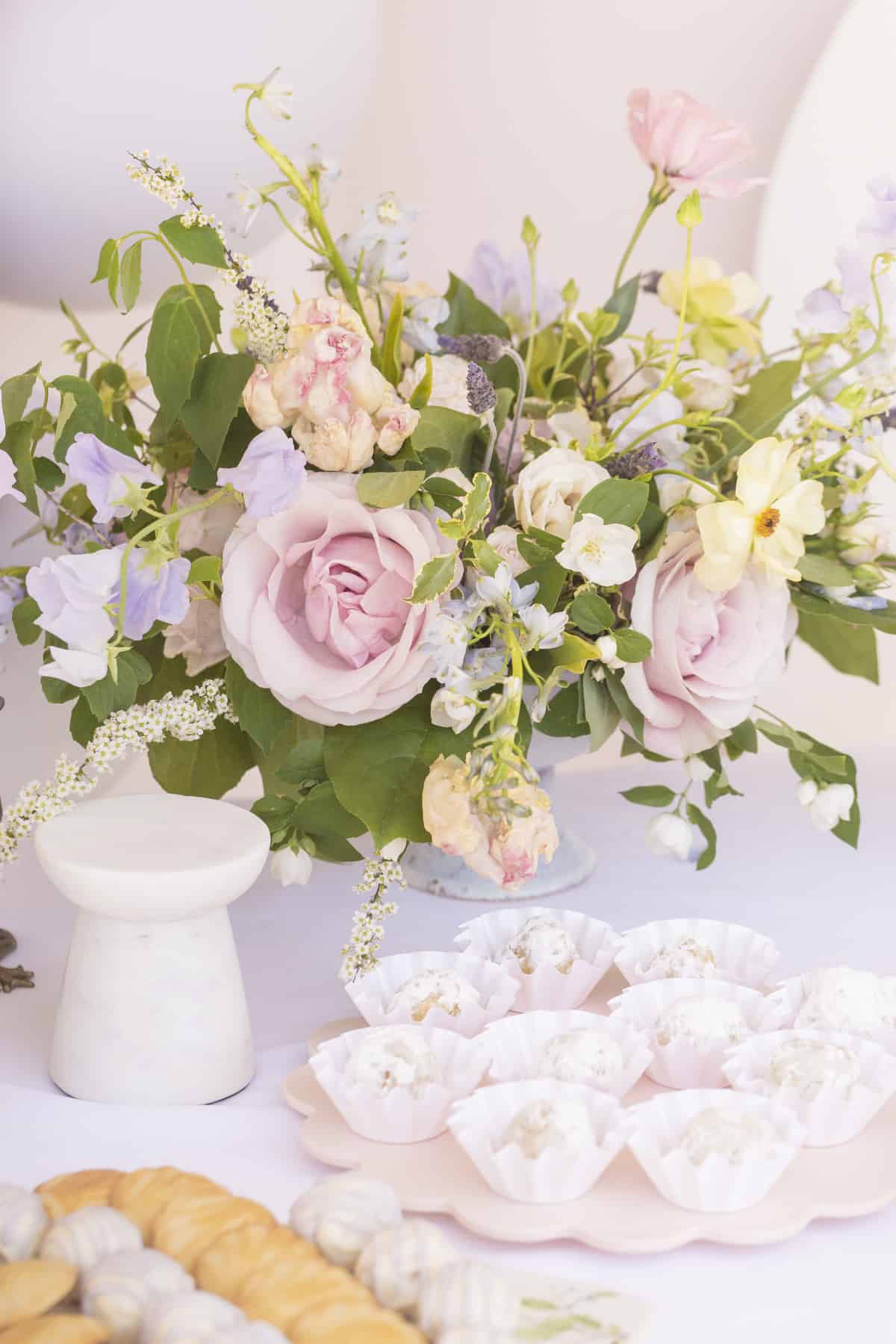 pink and blue flowers on a table with white tablecloth