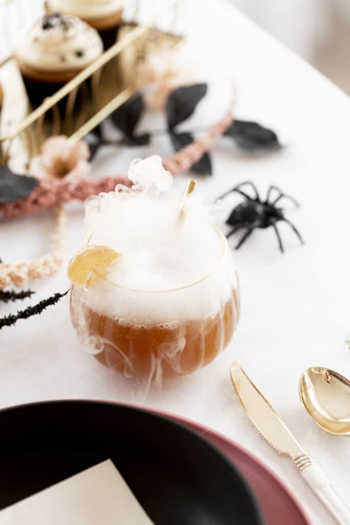 drink with dry ice on a table with a fake spider